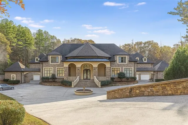 a front view of a house with a yard and lake view