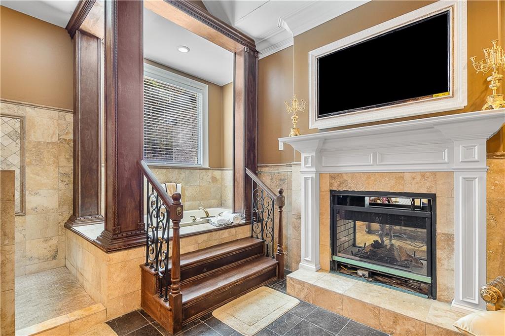 9830 Cedar Grove Road Fairburn, GA 30213 - Photo 36 of 55 a living room with a fireplace a flat screen tv and a window