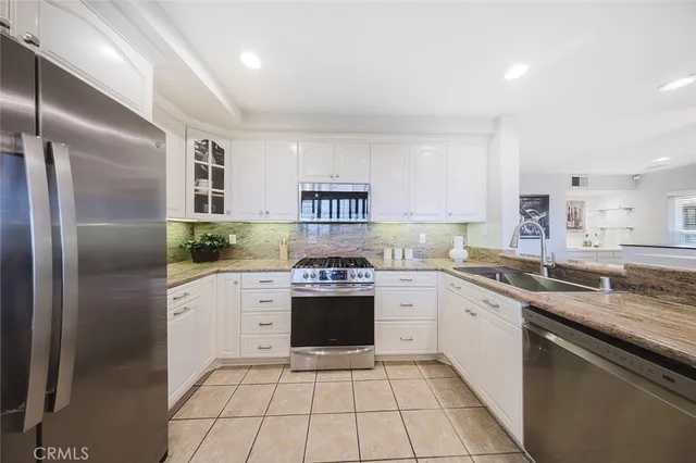 a kitchen with stainless steel appliances granite countertop a refrigerator sink and cabinets