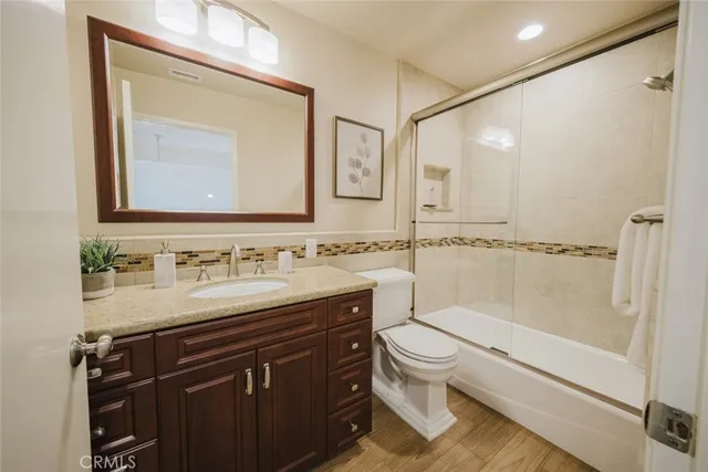 a view of a patio with a table and chairs under an umbrella with large trees