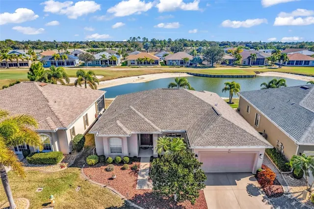 an aerial view of residential houses with outdoor space and ocean view