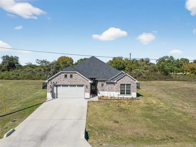 a view of a house next to a lake with a big yard