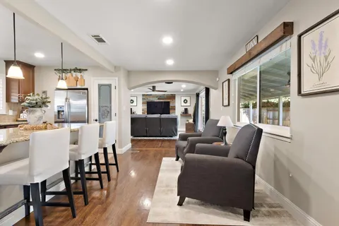 a living room with furniture a large window with kitchen view
