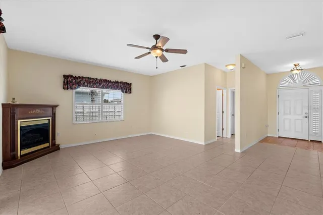 a view of an empty room with a fireplace and a window