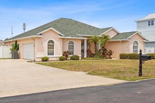 a view of a house with a yard and large tree