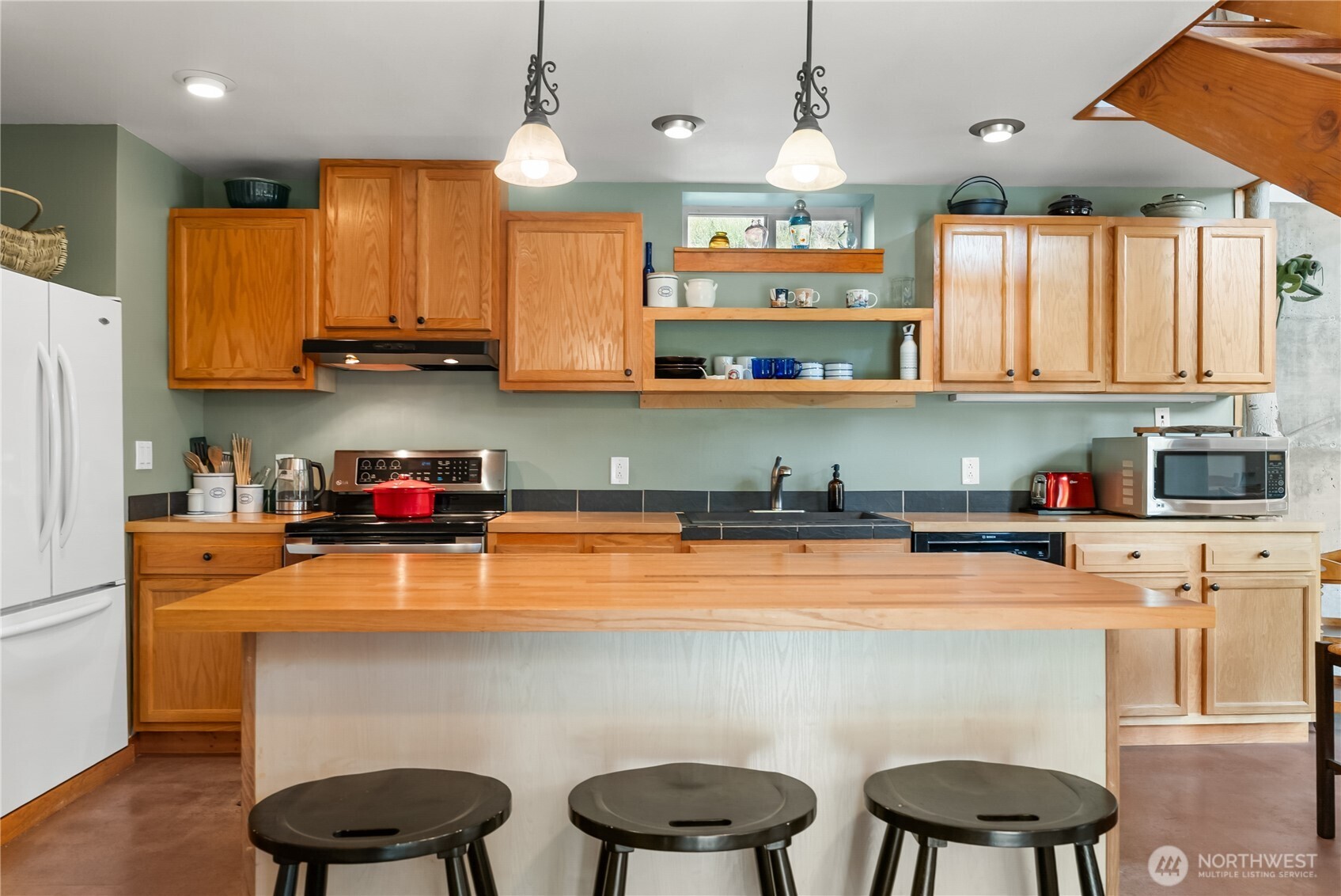 96 Alder Creek Road Twisp, WA 98856 - Photo 11 of 40 a kitchen with stainless steel appliances a sink a stove a refrigerator cabinets and a dining table