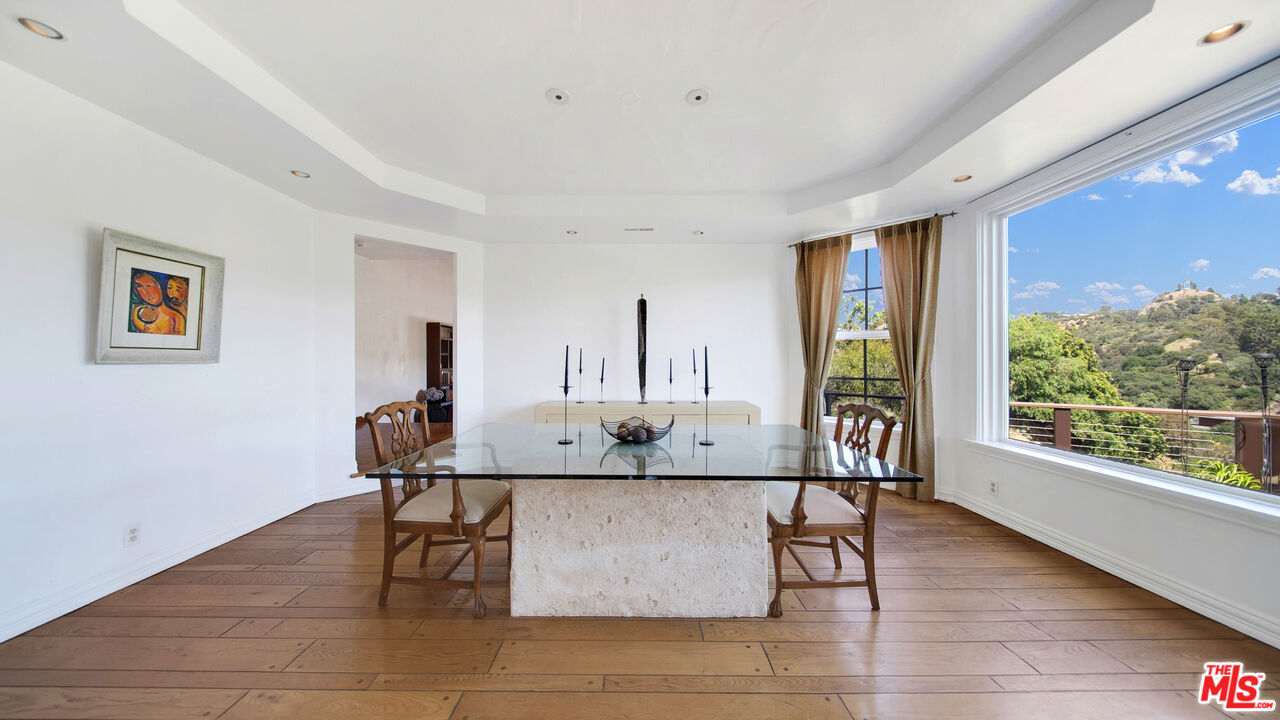 2312 Kimridge Road Beverly Hills, CA 90210 - Photo 10 of 60 a view of kitchen island with stainless steel appliances wooden floor dining table and chairs
