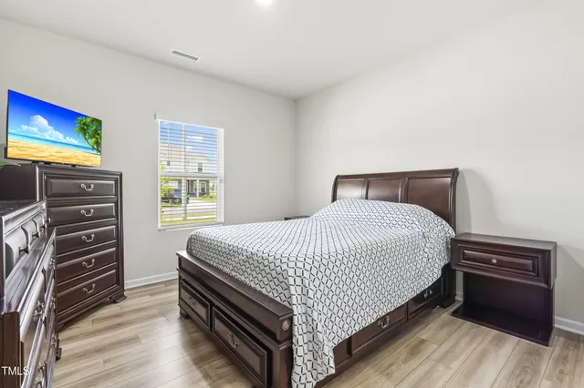 a kitchen with stainless steel appliances granite countertop a dining table chairs refrigerator and sink