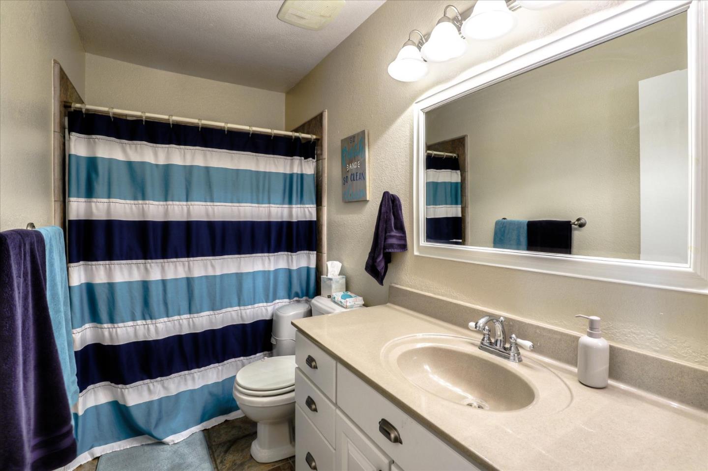 470 Corte Cabanil Morgan Hill, CA 95037 - Photo 14 of 22 a bathroom with a sink a toilet and shower curtain
