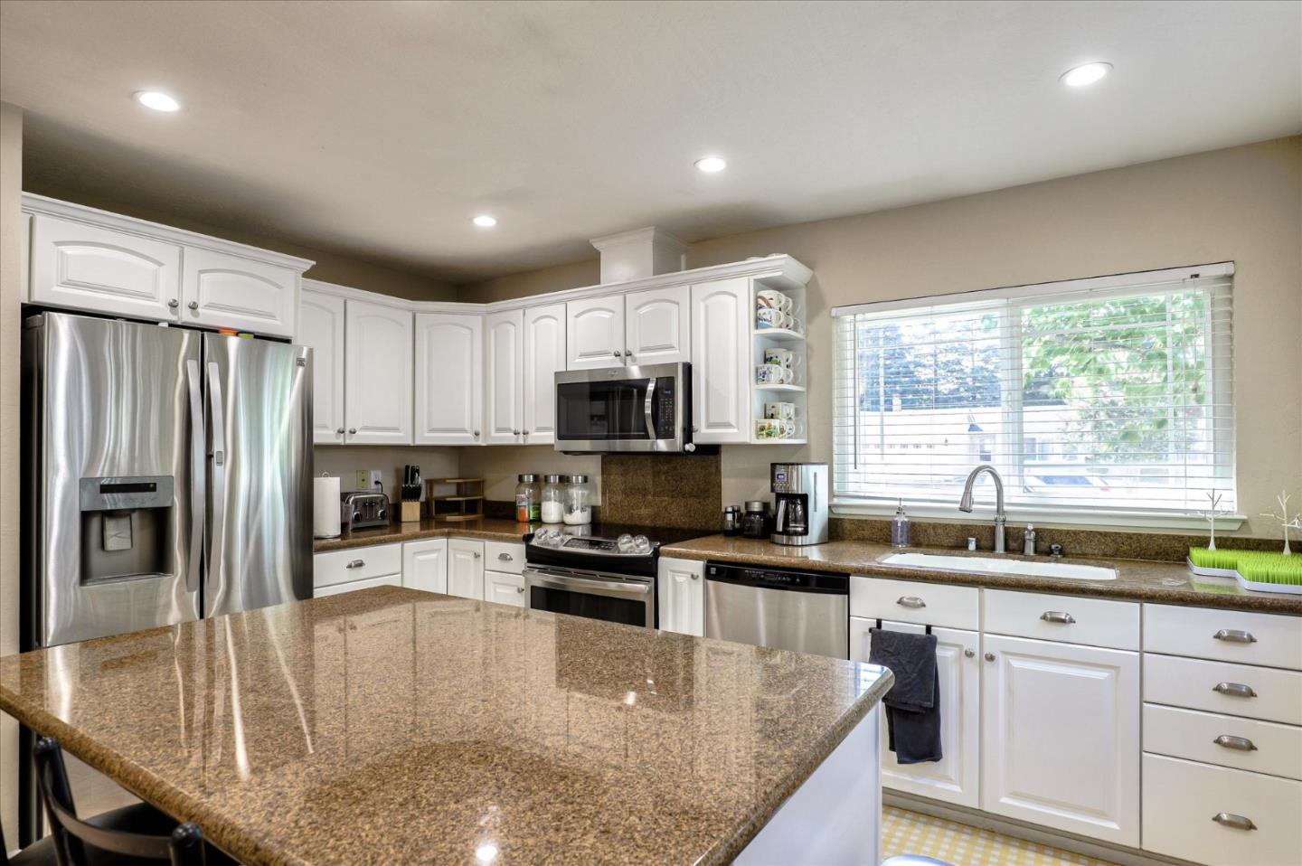 470 Corte Cabanil Morgan Hill, CA 95037 - Photo 9 of 22 a kitchen with stainless steel appliances granite countertop a sink refrigerator stove and microwave