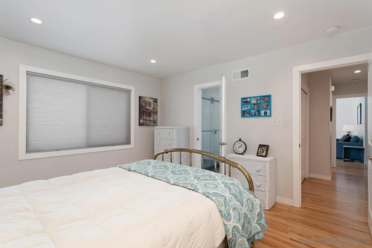 2435 Tuttle Street Carlsbad, CA 92008 - Photo 21 of 38 a bedroom with a large bed and wooden floor