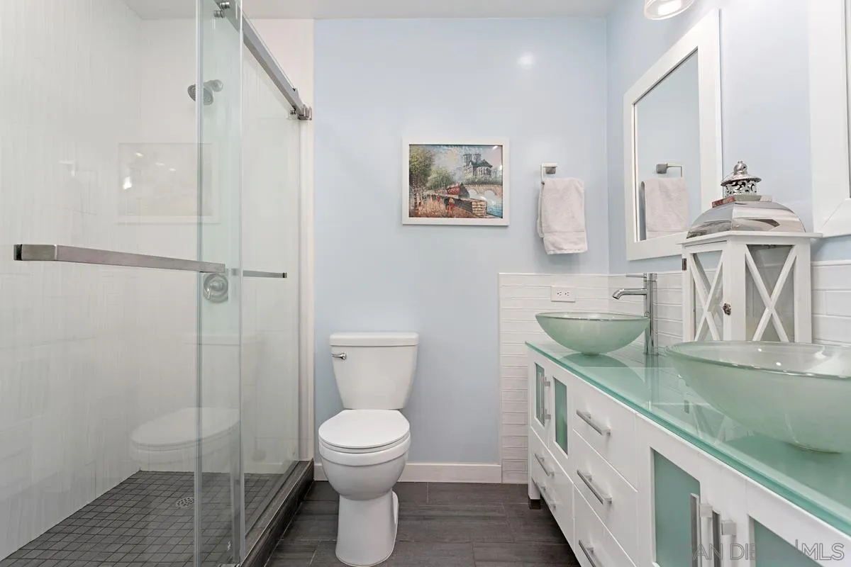2435 Tuttle Street Carlsbad, CA 92008 - Photo 23 of 38 a spacious bathroom with a granite countertop sink a toilet and a shower