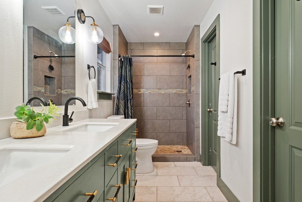 2800 River Road Wimberley, TX 78676 - Photo 19 of 40 Full bathroom featuring double vanity, a shower stall, and light tile patterned flooring