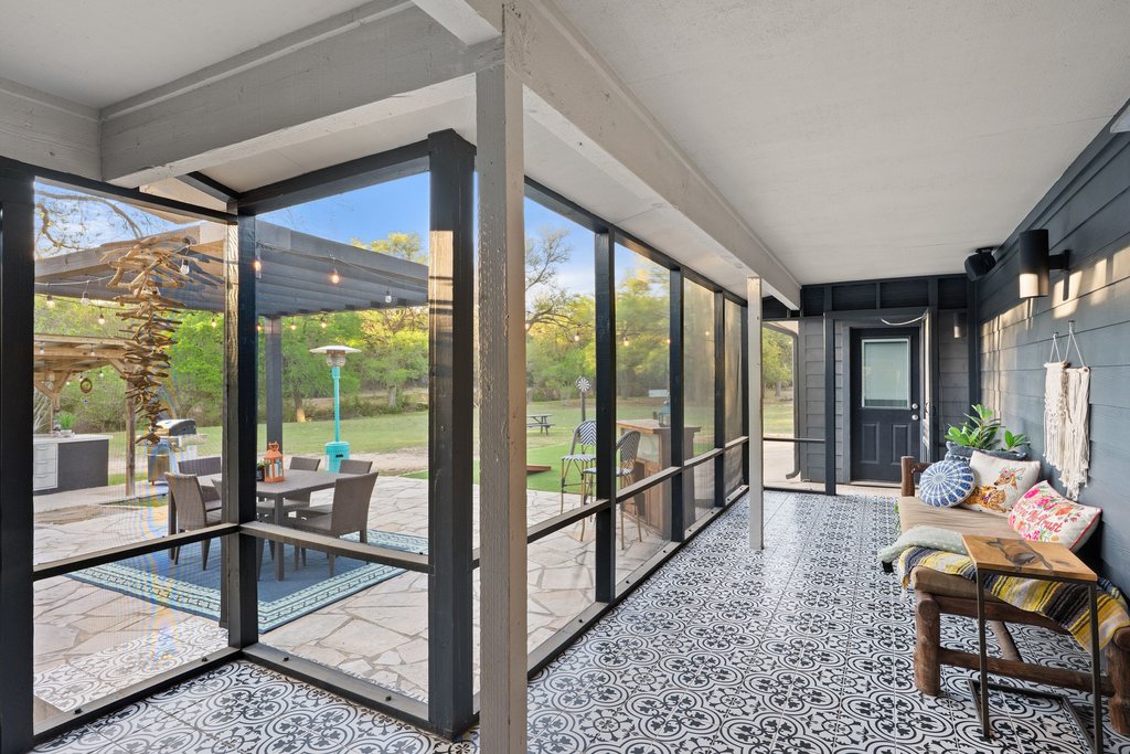 2800 River Road Wimberley, TX 78676 - Photo 24 of 38 Sunroom featuring floor to ceiling windows and tile patterned floors