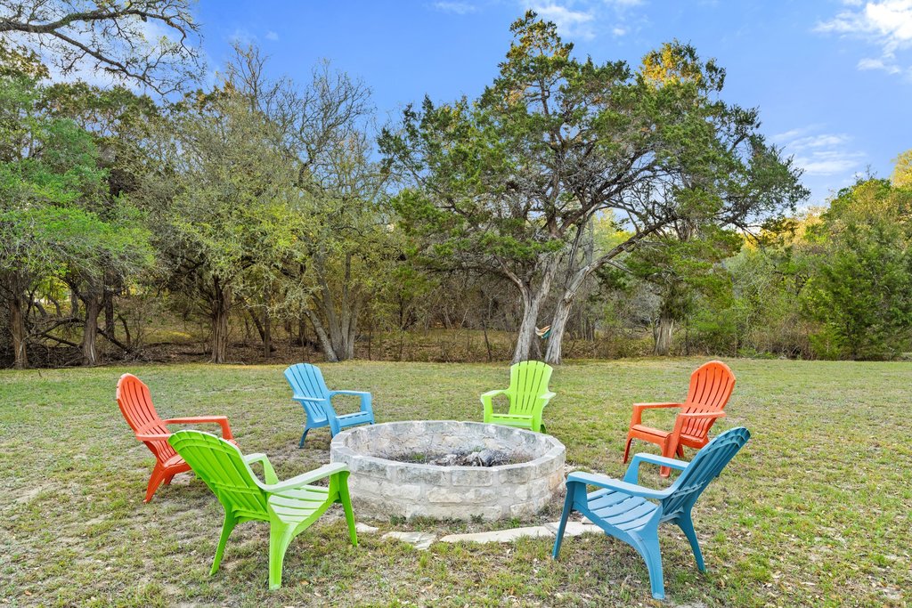 2800 River Road Wimberley, TX 78676 - Photo 28 of 40 View of green lawn with an outdoor fire pit and a patio