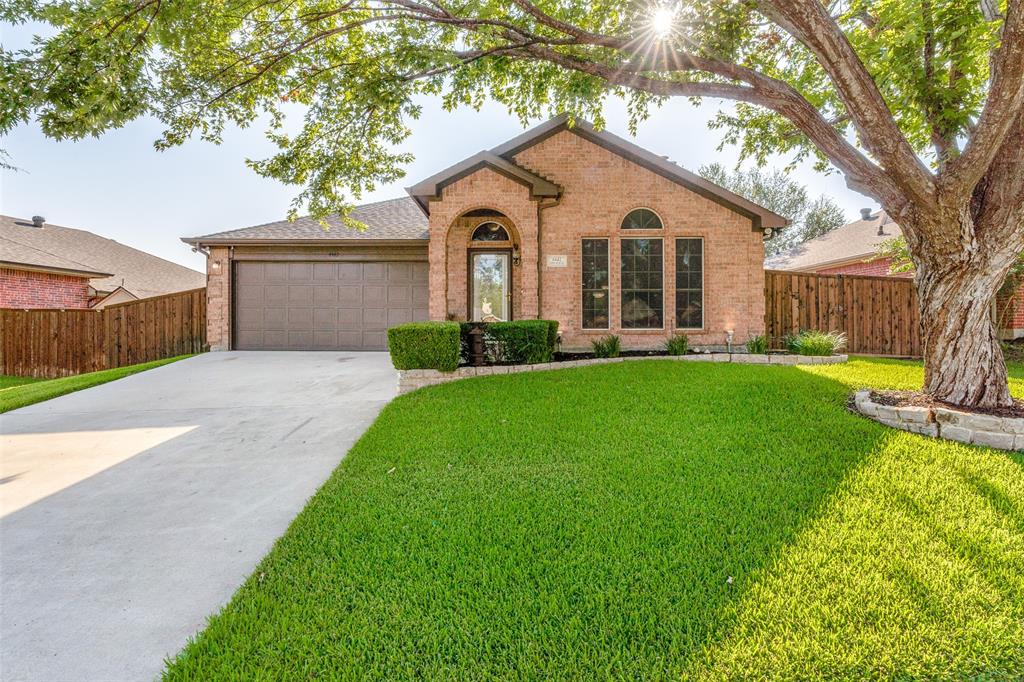 a view of a house with a yard and a large tree