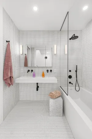 a bathroom with a tub sink shower and mirror