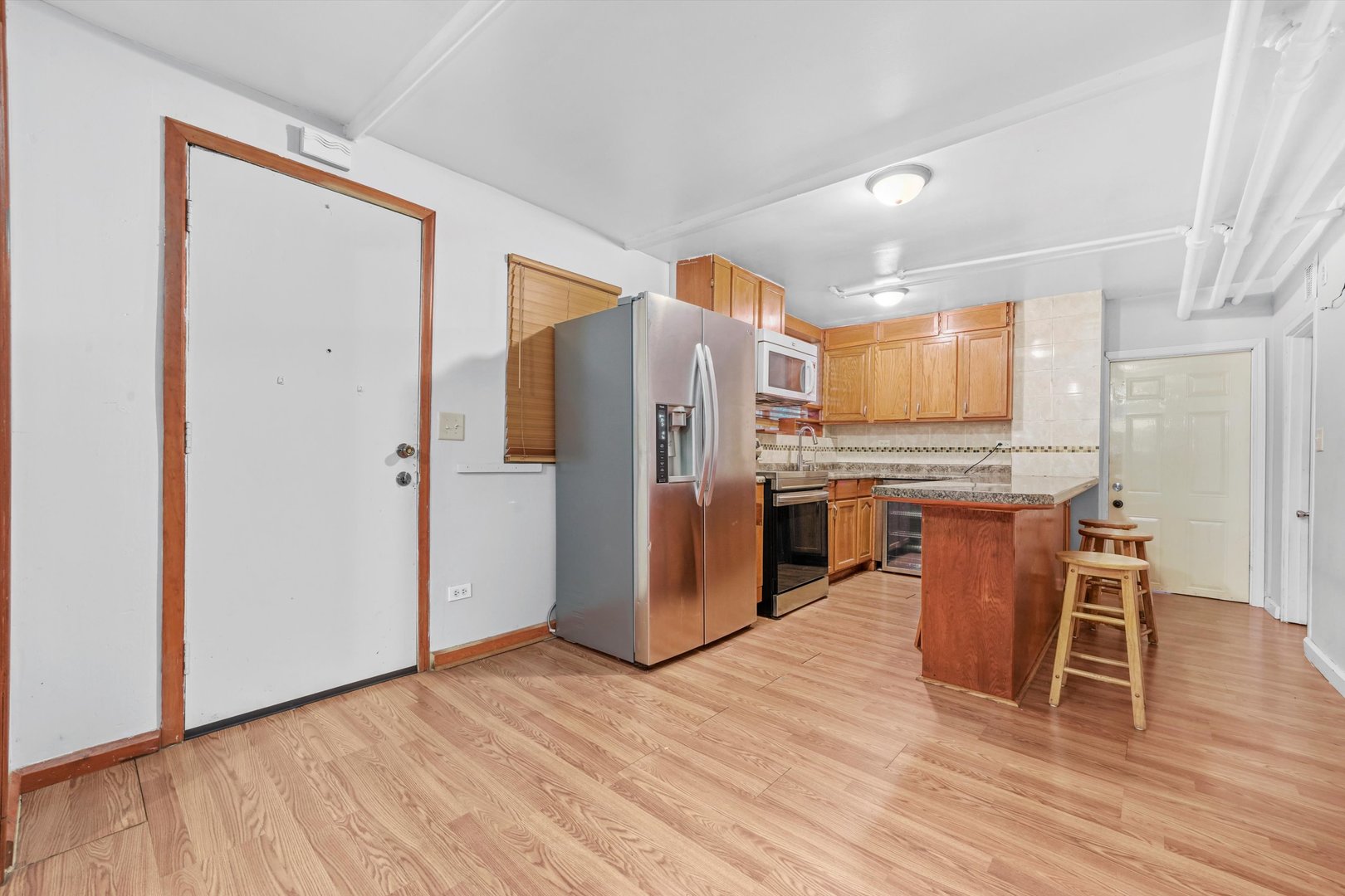 1450 North Springfield Avenue Chicago, IL 60651 - Photo 15 of 46 a kitchen with stainless steel appliances a refrigerator and wooden floor