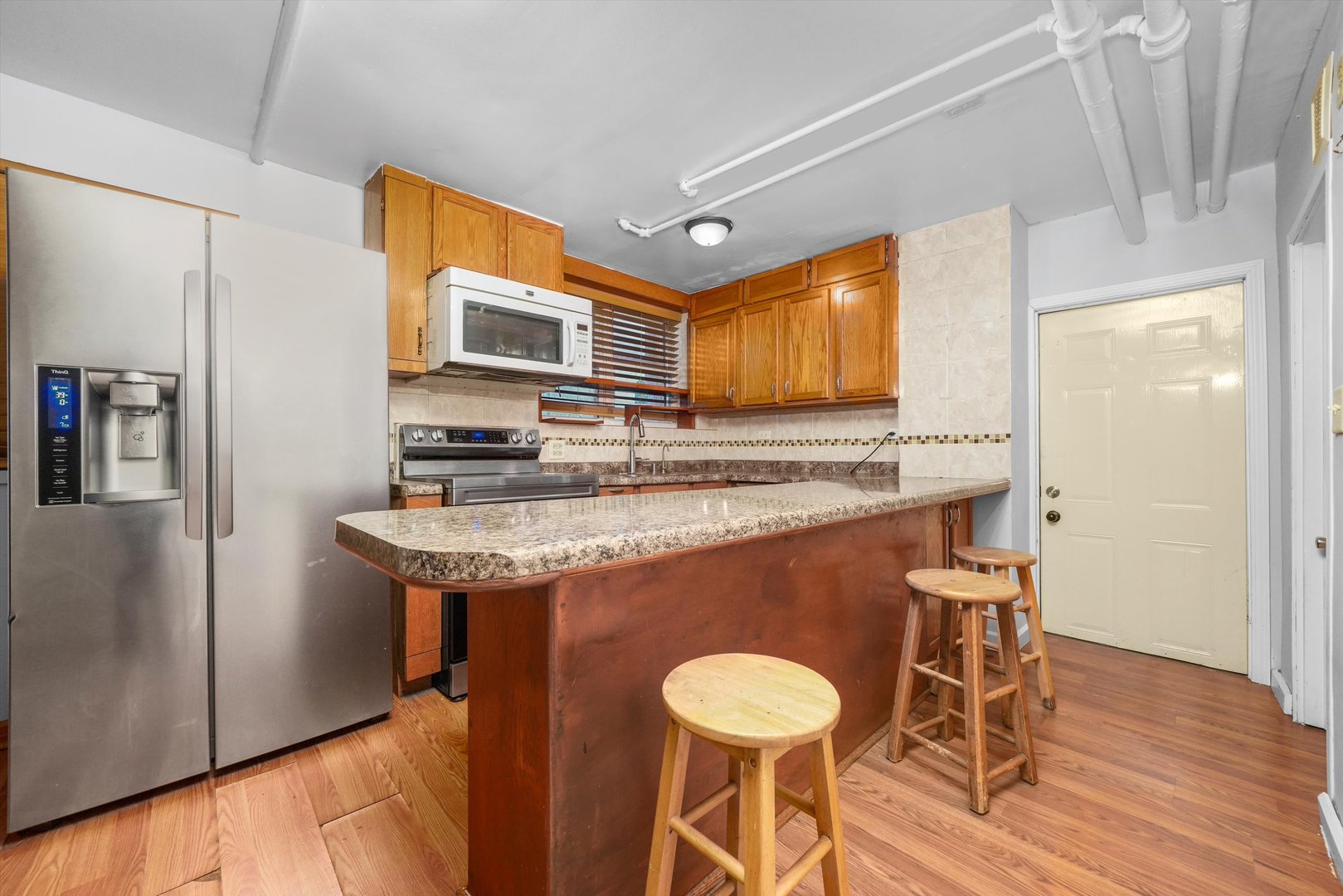 1450 North Springfield Avenue Chicago, IL 60651 - Photo 17 of 46 a kitchen with stainless steel appliances granite countertop a sink and a refrigerator