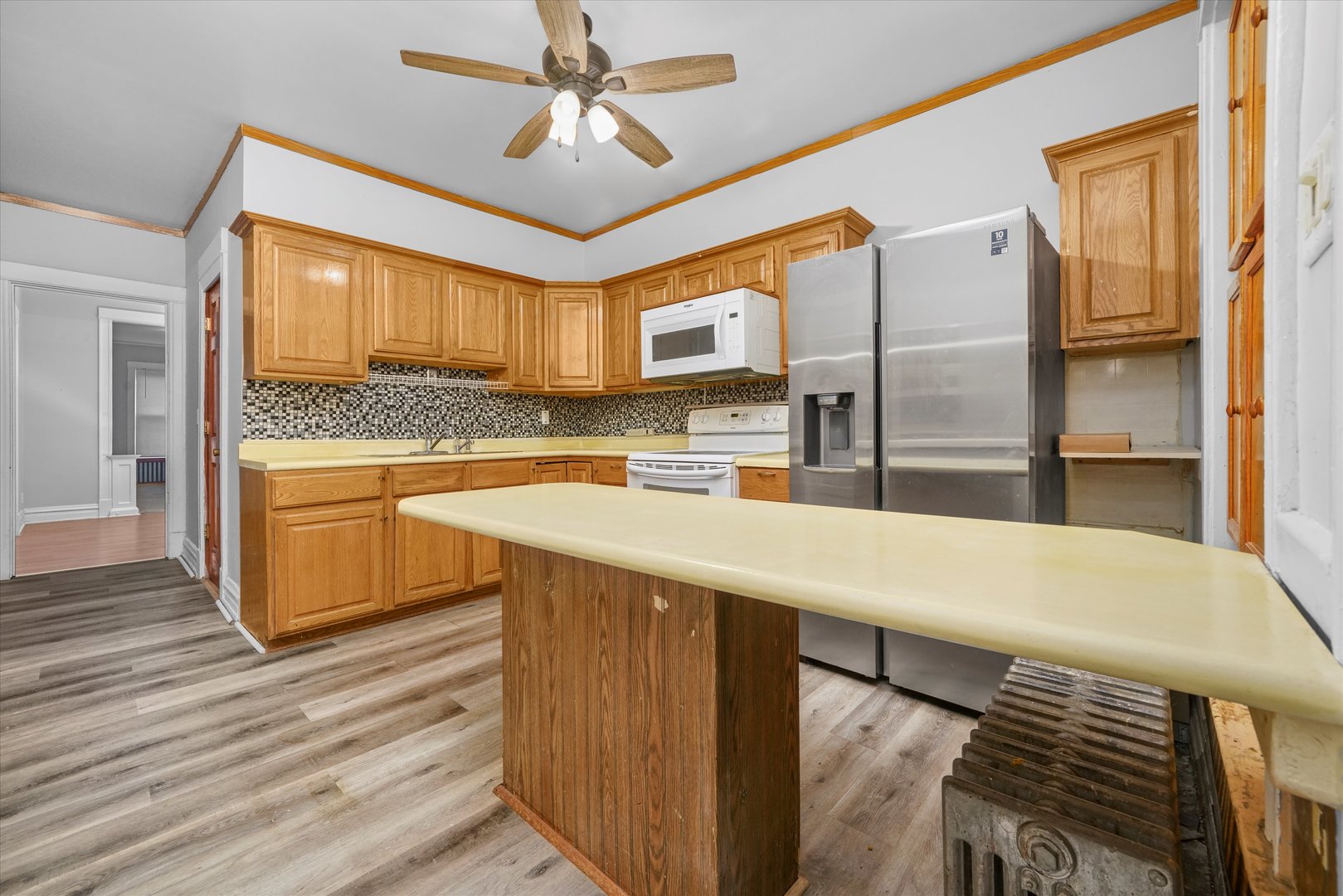 1450 North Springfield Avenue Chicago, IL 60651 - Photo 4 of 46 a kitchen with stainless steel appliances kitchen island granite countertop a table chairs in it and wooden floors