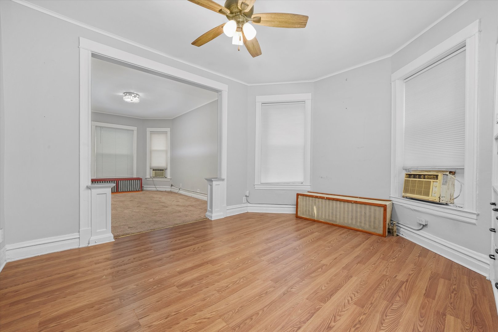 1450 North Springfield Avenue Chicago, IL 60651 - Photo 6 of 46 a view of an empty room with window a ceiling fan and wooden floor