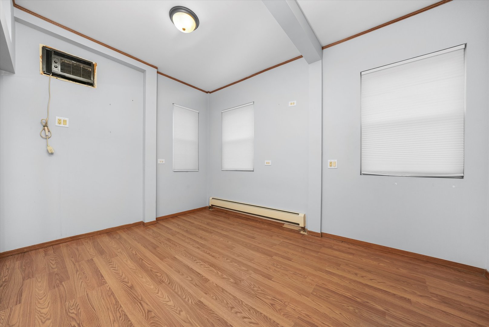 1450 North Springfield Avenue Chicago, IL 60651 - Photo 9 of 46 an empty room with wooden floor and windows