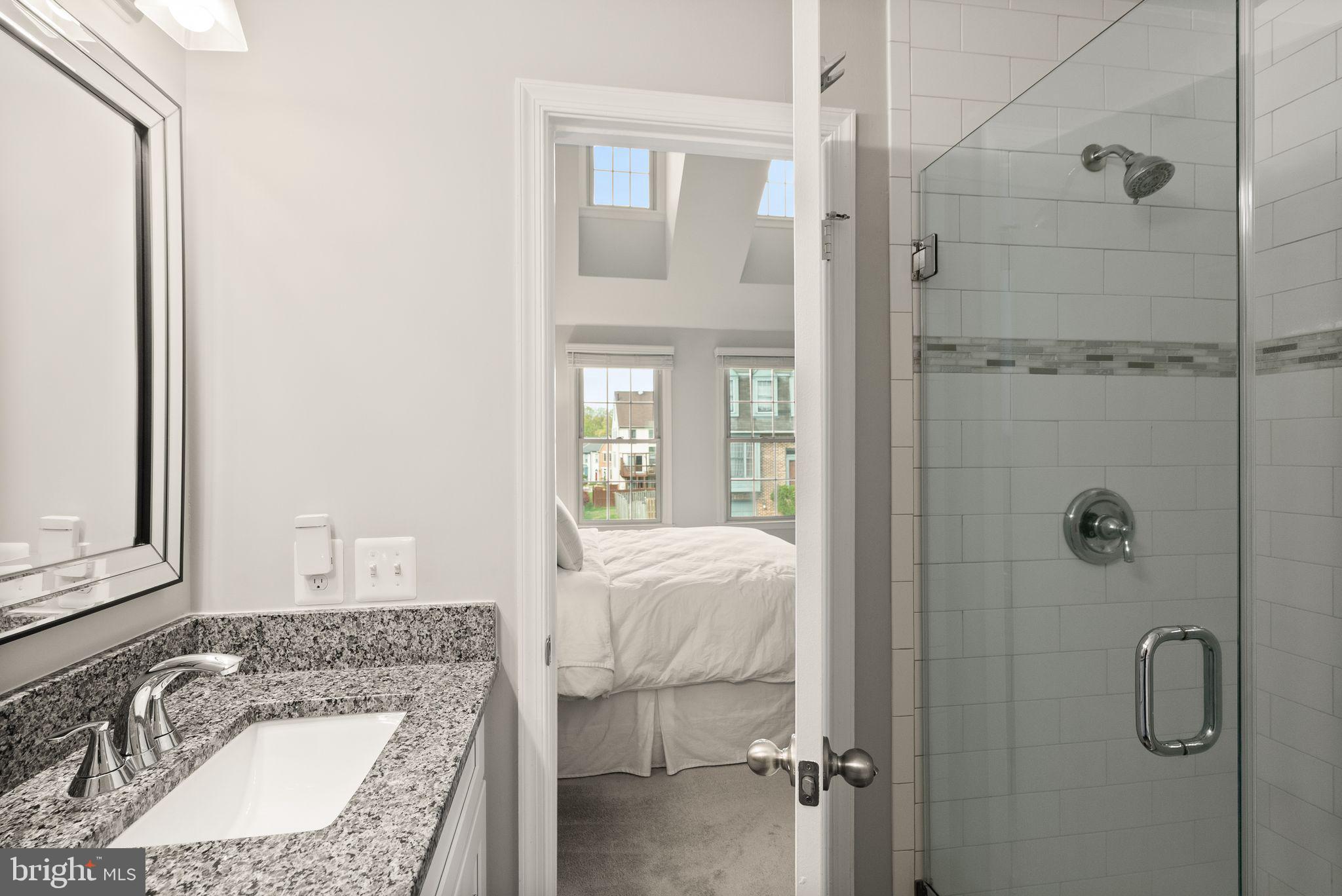 6369 English Ivy Way Springfield, VA 22152 - Photo 36 of 62 a bathroom with a granite countertop sink a mirror and shower