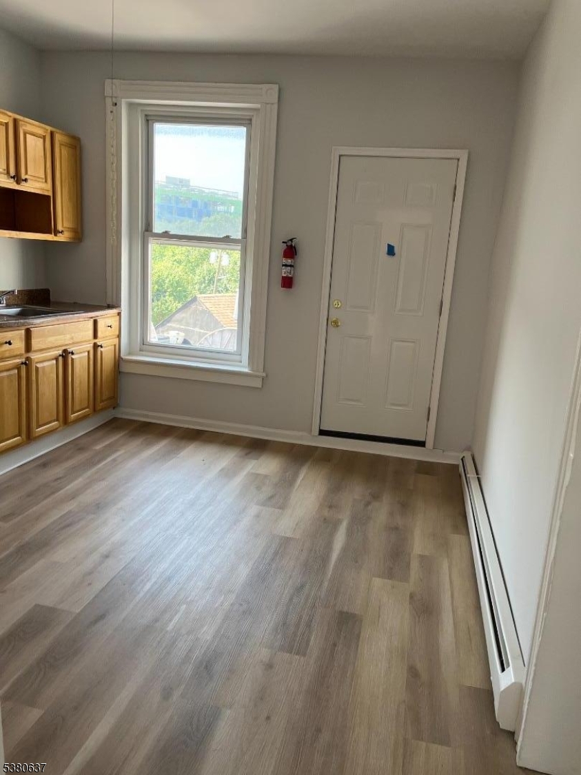304 Morris Avenue Elizabeth, NJ 07208 - Photo 4 of 9 an empty room with wooden floor and windows