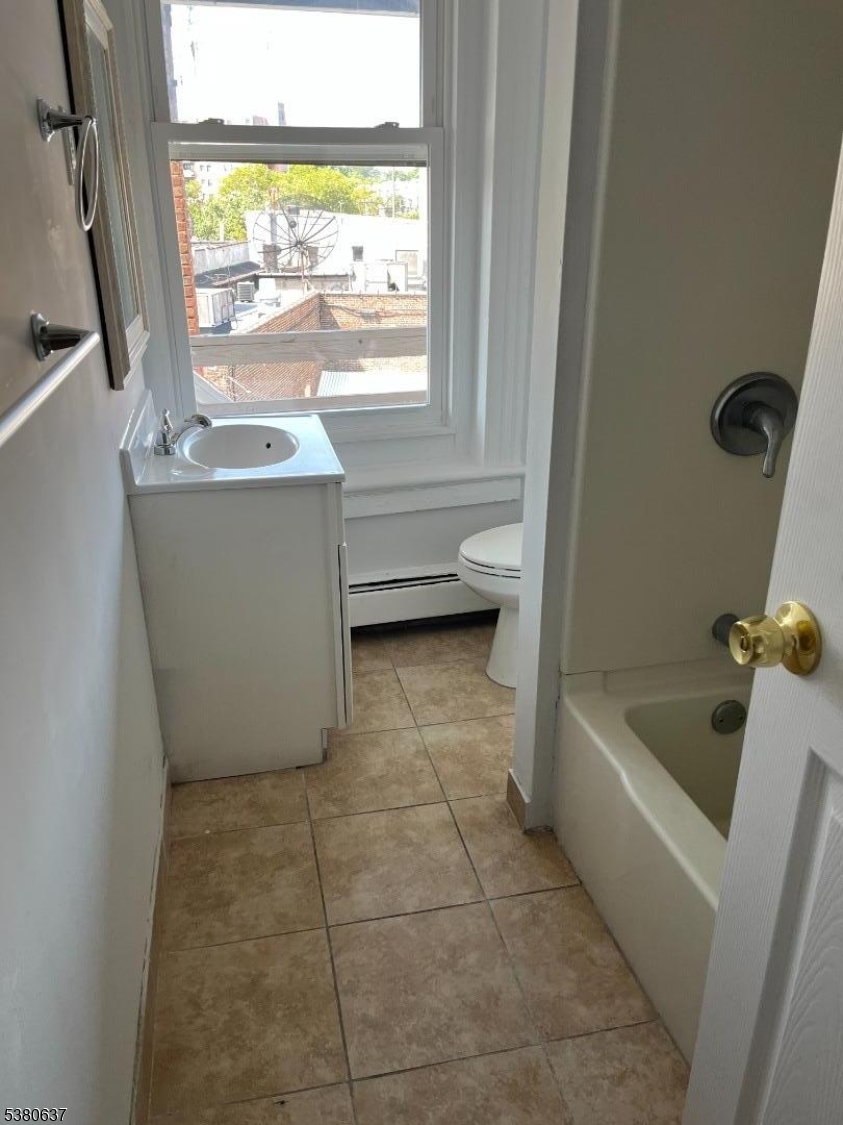304 Morris Avenue Elizabeth, NJ 07208 - Photo 6 of 9 a bathroom with a tub a sink a window and a shower