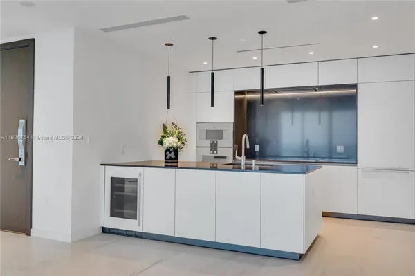 a kitchen with stainless steel appliances a sink a faucet a potted plant and a counter space