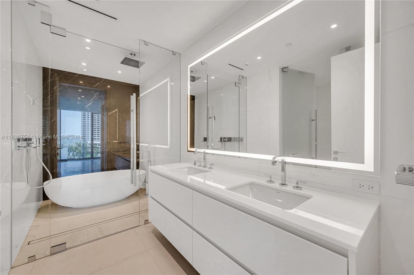 300 Biscayne Blvd Way, Unit 703 Miami, FL 33131 - Photo 17 of 27 a bathroom with a sink double vanity mirror and a bathtub