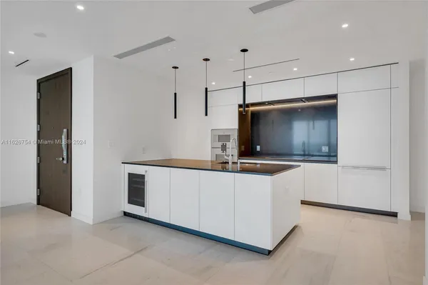 a large kitchen with kitchen island a sink stainless steel appliances and cabinets