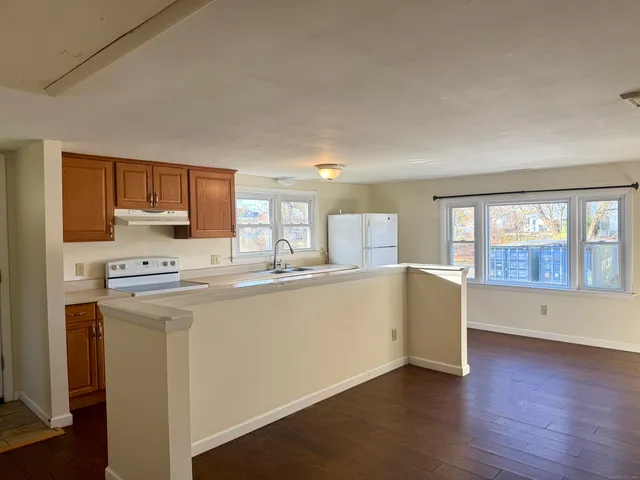 a large kitchen with wooden floors and white stainless steel appliances