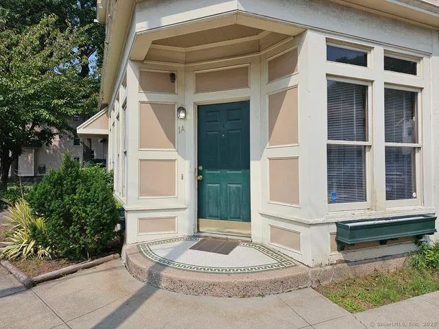 a front view of white house with a yard