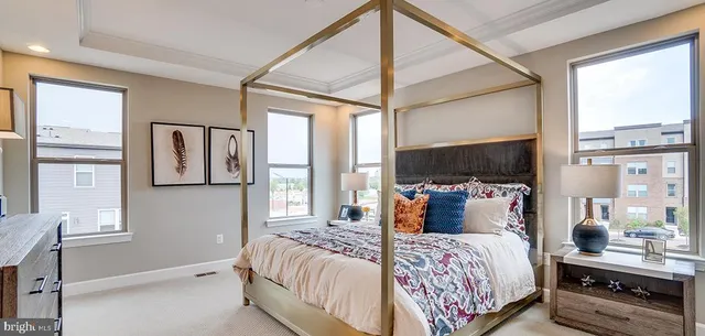 a bedroom with a bed and large windows