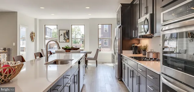 a kitchen with stainless steel appliances granite countertop a sink a stove and a refrigerator