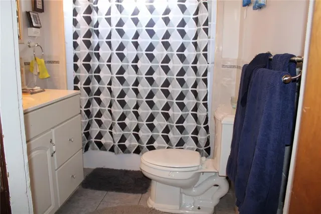 a bathroom with a toilet and a shower curtain