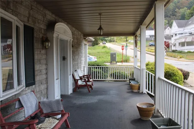 a view of a porch with wooden floor and outdoor seating