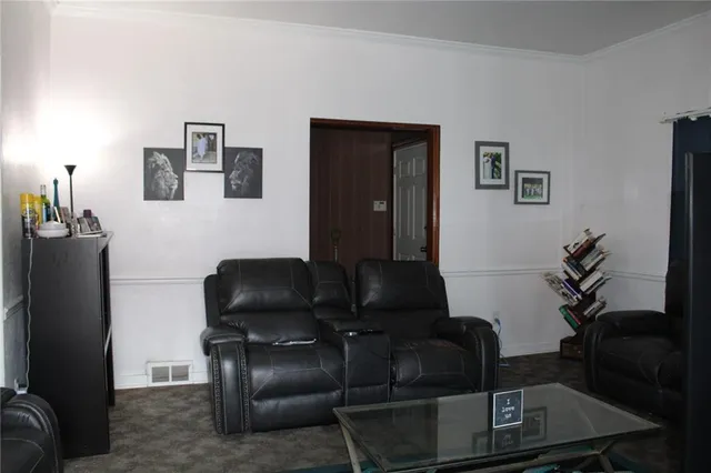 a living room with furniture and a painting on the wall