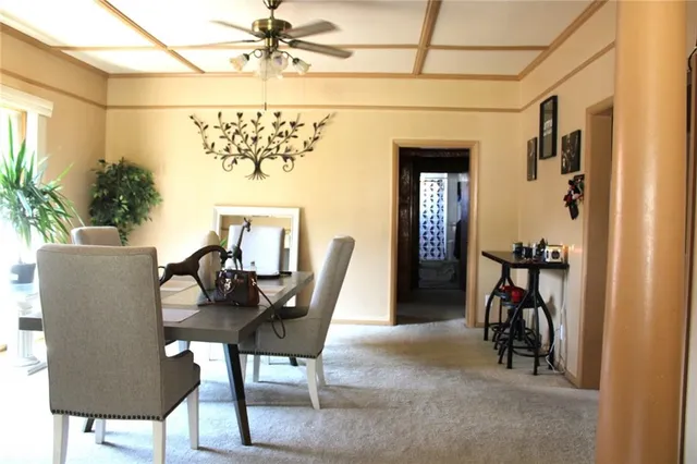 a view of a dining room with furniture and a chandelier