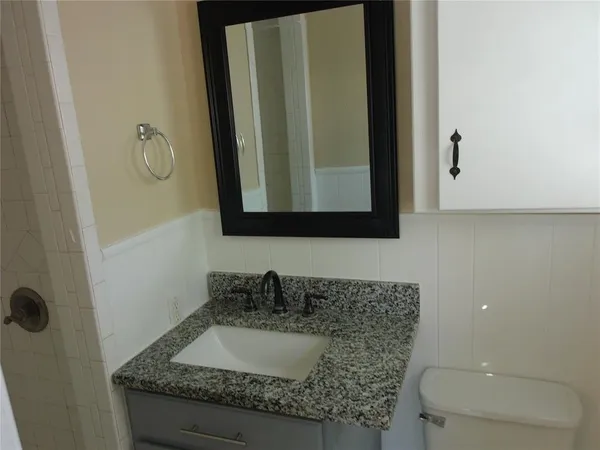 a bathroom with mirror granite and a sink