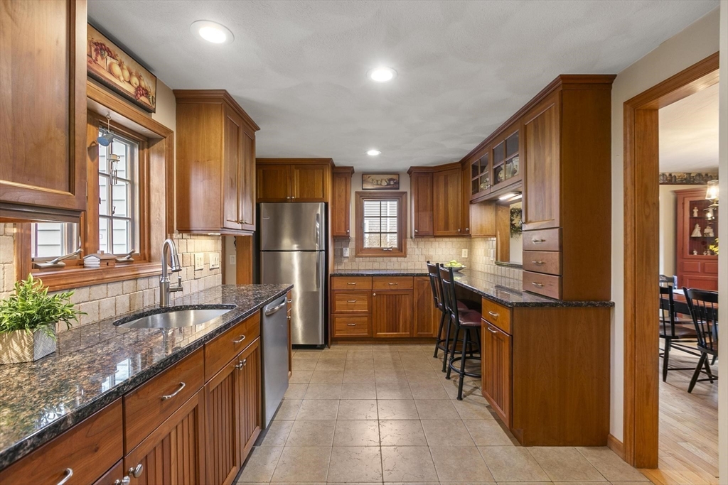 19 Dustin Road Reading, MA 01867 - Photo 11 of 33 a kitchen with stainless steel appliances granite countertop a sink and cabinets