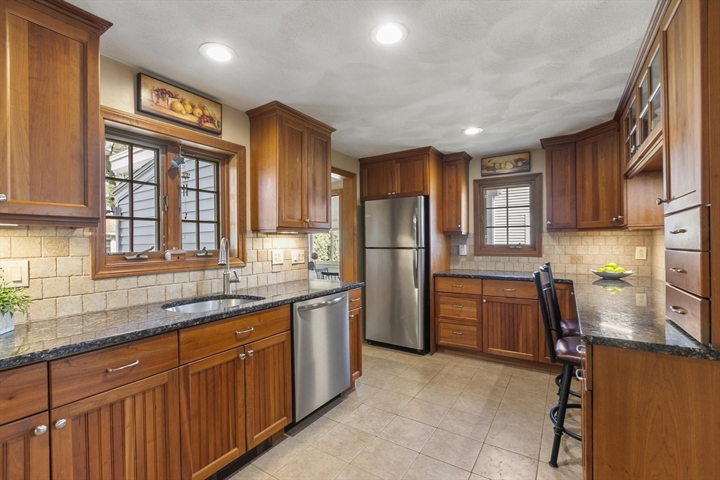 19 Dustin Road Reading, MA 01867 - Photo 12 of 33 a kitchen with stainless steel appliances granite countertop a refrigerator and a sink