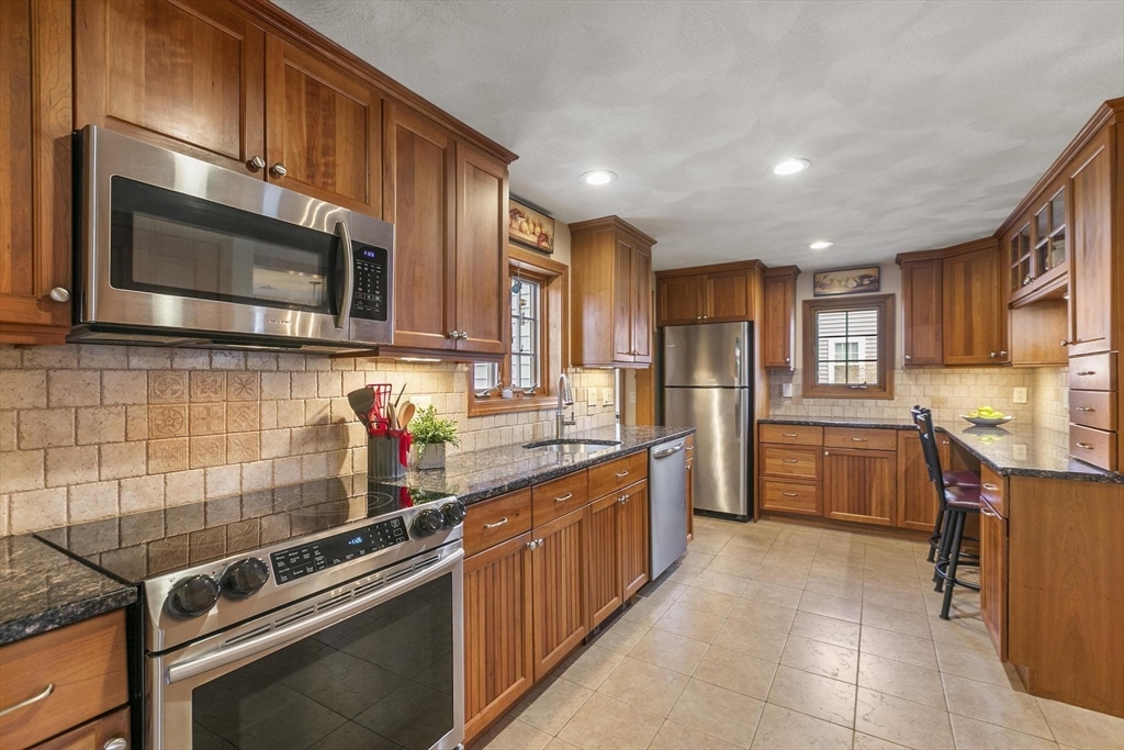 19 Dustin Road Reading, MA 01867 - Photo 13 of 33 a kitchen with stainless steel appliances and view of cabinets