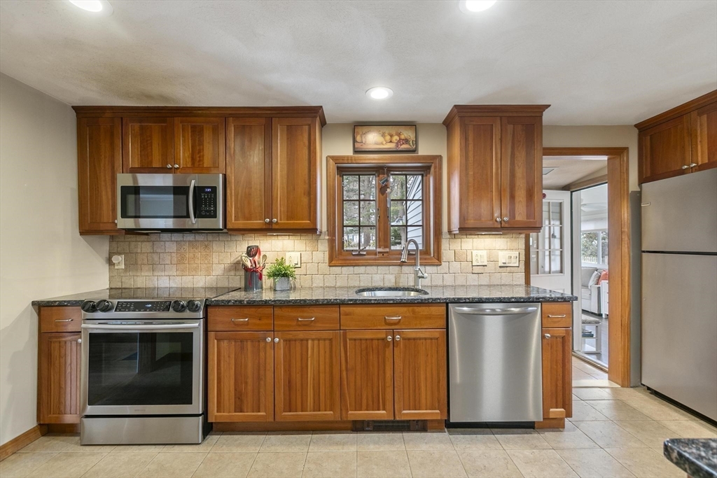 19 Dustin Road Reading, MA 01867 - Photo 14 of 33 a kitchen with granite countertop stainless steel appliances and wooden cabinets