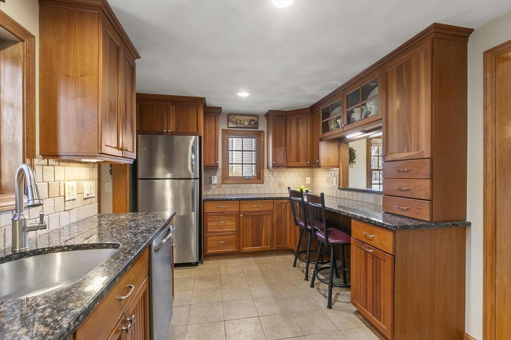 19 Dustin Road Reading, MA 01867 - Photo 15 of 33 a kitchen with stainless steel appliances granite countertop a refrigerator and a stove top oven