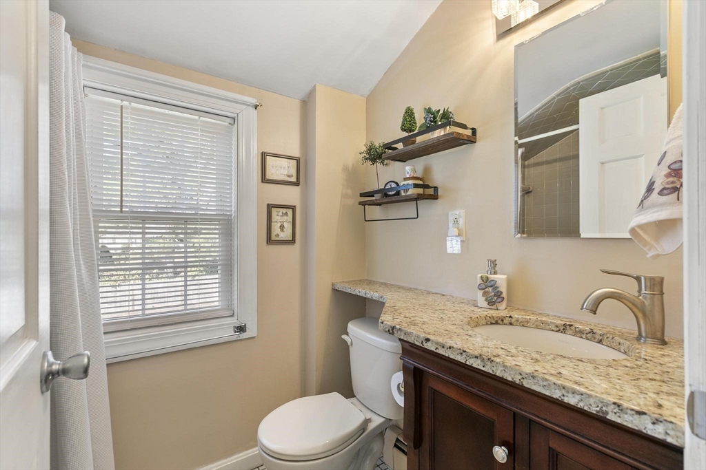 19 Dustin Road Reading, MA 01867 - Photo 29 of 33 a bathroom with a granite countertop sink toilet and mirror