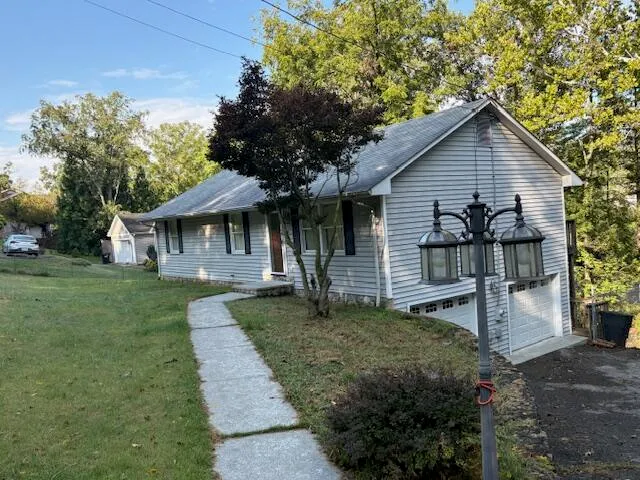 a front view of a house with a yard and trees