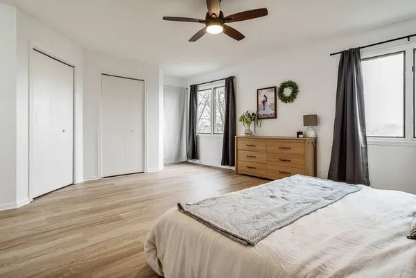 a spacious bedroom with a bed and a ceiling fan