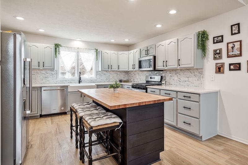 186 Lake Summerset Road Davis, IL 61019 - Photo 8 of 58 a kitchen with stainless steel appliances granite countertop a sink a stove a refrigerator and island with wooden floor